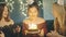 Young woman blowing out fire on candles and making wish at party or celebration. Close-up portrait of smiling asian girl