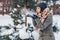Young woman blowing snow in winter forest. Girl having fun outdoors
