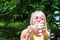 Young woman blows soap bubbles in the street. Close-up portrait. Happiness and positive emotions concept