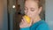 Young woman in a blue blouse inhales the aroma of fresh lemon.