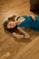 Young woman in a blue dress lays on a parquet