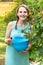 Young woman in blue dress picking blackberries