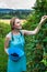 Young woman in blue dress picking blackberries