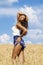 young woman in blue shorts in a wheat golden field