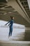 Young woman in blue track suit taking jump by the river at autumn morning