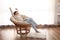 Young woman with book resting on lounge chair at home