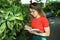 Young woman botanist take a notes in a botanical garden