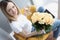 Young woman with bouquet of tea roses sitting at laptop with glass of white wine