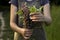 A young woman with a bouquet of wild flowers in her hands is standing in a meadow, close-up. Summer background. concept