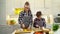 Young woman with boy cutting vegetables