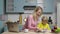 Young woman and a boy draw with felt-tip pens in an album. Mom and son in kitchen. Family bloggers filming stories for