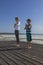 Young woman and boy make a sun salutation with folded palms near the heart,