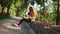 Young woman in bra doing reverse push ups in the park listening to the music. Slowmotion shot