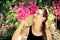 Young woman with braid smelling pink flowers