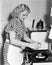 Young woman breaking an egg into a frying pan