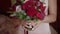 Young woman bride holding bouquet in hands standing in home interior.