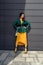 Young woman in bright clothes, yellow skirt and green jacket. Yellow socks in sandals, beret on the head, hair with the