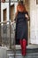 Young woman with bright long red hair on a city street.