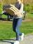 Young woman bringing many pizza boxes. Picnic in the park