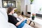 Young woman browsing decorating magazine in her living room. Reforms, lifestyle and interiors