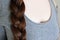 Young woman, brunette, braids her long beautiful hair in thick braid, concept of hygiene, hair care, traditions