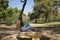 Young woman, brunette, slender, dressed in green T-shirt and jeans, sitting on a stone bench, alone, sad, serious. Concept