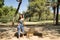 Young woman, brunette, slender, dressed in green T-shirt and jeans, sitting on a stone bench, alone, sad, serious. Concept