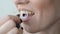 Young woman brushes her teeth with a floss