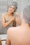 Young woman brushes her white teeth with a bamboo brush with paste.