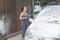 Young woman with bucket and rag washing red car