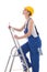 Young woman builder in blue coveralls with screwdriver on ladder
