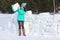 Young woman builds snow castle wall of snow blocks. Winter vacation. Winter and new year holidays