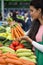 Young woman buying vegetables on the market