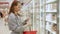 Young woman buys a dairy product and reads the labels on food in a grocery store.