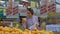 A young woman buys oranges in the supermarket