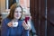 Young woman at cafe drinking coffee and using smartphone and wifi, connects to friends, downloads app or application from internet