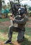 Young woman in camouflage holding gun before paintball match with friends