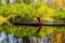 Young woman in canoe with oars swims on  river in jungle