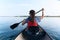 Young woman canoeing in the lake on a summer day.