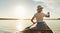 Young woman canoeing on a still lake in the summer