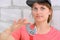 A young woman in a cap holding a large adjustable wrench. Plumber repairs and holds a red wrench