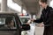 young woman in car giving driver license to policewoman