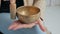 Young woman in cardigan relaxing with nepal singing bowl