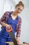 Young woman carpenter cutting a board with handsaw