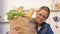 Young woman carrying heavy paper bag with products from shop, needs delivery