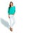 Young woman in casual attire, vibrant green sweater, white jeans, isolated on a white background. She stands confidently, hand in