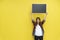 Young woman in casual show an empty blackboard on yellow wall with smiling