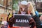 Young woman with cat mask on face, have a sign KARMA in her hands, during `March for animals` in Riga, Latvia.