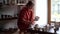 Young woman ceramist holding brush applying liquid coating on handcrafted pottery