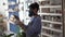 Young woman ceramist wearing respirator sanding ceramics with grinding block in pottery studio